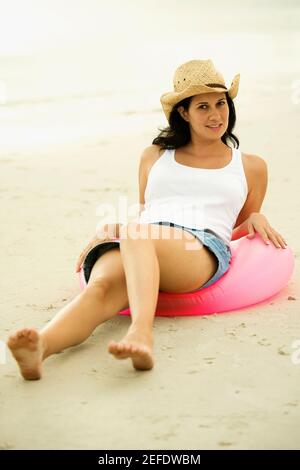 Portrait d'une jeune femme assise sur un anneau gonflable Banque D'Images