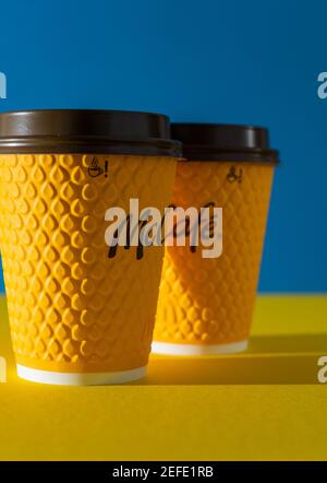 Ukraine, Kiev - 17 février 2021 : verre de café jaune de McDonald's. Verre en papier boisson McCafe. Coupe en offee sur table avec ombres. Menu dans fastfood Banque D'Images