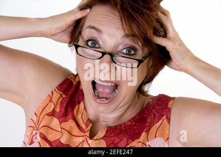 Portrait d'une femme âgée avec ses mains sur elle tête Banque D'Images