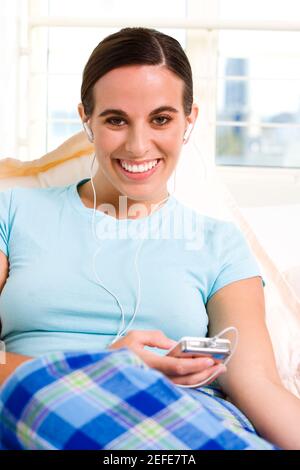 Portrait d'une jeune femme de l'écoute d'un MP3 player Banque D'Images