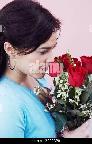 Gros plan d'une jeune femme tenant un bouquet de roses Banque D'Images