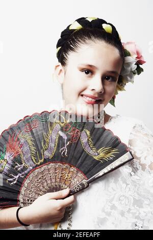 Portrait d'une fille tenant un ventilateur pliant et souriant Banque D'Images