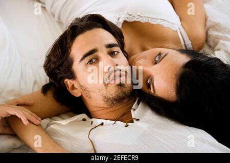 Portrait d'un jeune homme couché avec une jeune femme sur le lit Banque D'Images