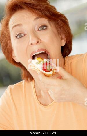 Portrait d'une femme âgée mangeant une tarte aux fruits Banque D'Images
