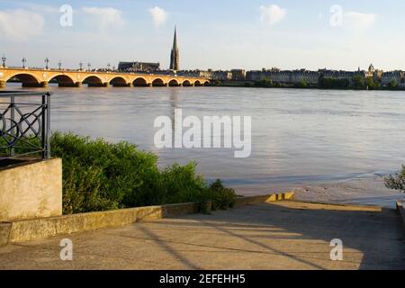 Pont d'arche traversant une rivière, Pont de Pierre, Basilique Saint-Michel, Rivière Garonne, Bordeaux, Aquitaine, France Banque D'Images