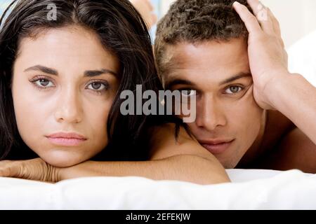 Portrait d'un jeune couple lying on a bed Banque D'Images