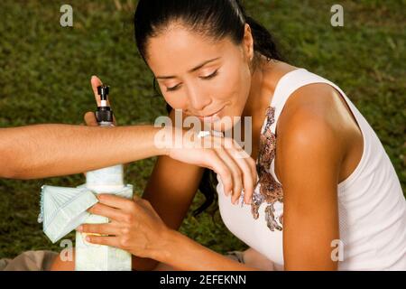 Gros plan d'une jeune femme tenant une bouteille de lotion Banque D'Images