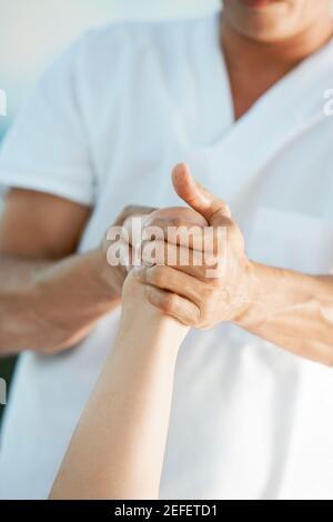 Vue en milieu de section d'un massothérapeute offrant un massage des pieds à une femme Banque D'Images