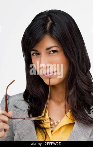 Portrait d'une jeune femme tenant une paire de lunettes Banque D'Images