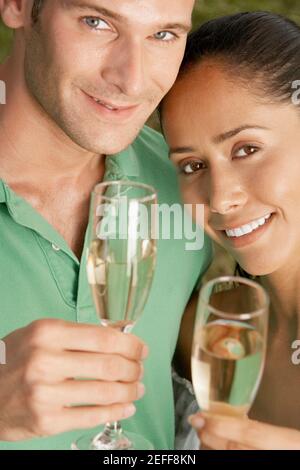 Portrait of a young couple holding champagne flutes Banque D'Images