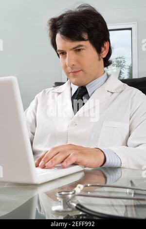 Médecin de sexe masculin utilisant un ordinateur portable dans une clinique Banque D'Images