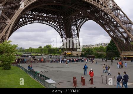 Touristes sous une tour, Tour Eiffel, Paris, France Banque D'Images
