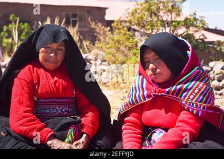 Gros plan de deux femmes matures prenant part à une cérémonie de mariage, île Taquile, lac Titicaca, Puno, Pérou Banque D'Images