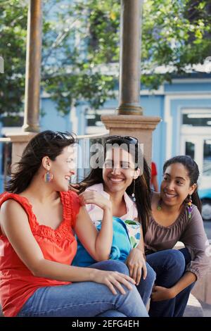 Trois jeunes femmes siégeant ensemble et souriant, le vieux San Juan, San Juan, Puerto Rico Banque D'Images