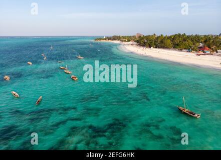 Top vue sur les bateaux traditionnels africains en bois sur l'eau turquoise propre près de la côte de Zanzibar à la plage de Nungwi. Prise de vue aérienne Banque D'Images