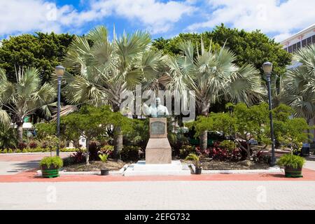 Buste sur un piédestal devant les arbres, Sir Milo Boughton Butler, Rawson Square, Nassau, Bahamas Banque D'Images