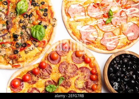 différentes sortes de pizzas dans assortiment avec basilic vert, champignons, tomates, fromage, poivre pour le menu. Gros plan. Repas de restauration rapide ou pizza de fête dinn Banque D'Images