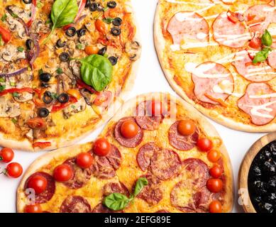 différentes sortes de pizzas dans assortiment avec basilic vert, champignons, tomates, fromage, poivre pour le menu. Gros plan. Repas de restauration rapide ou pizza de fête dinn Banque D'Images
