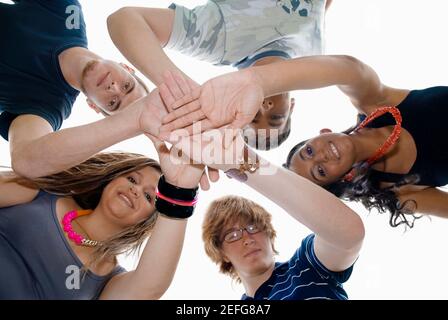 Low angle view of cinq amis leurs mains d'empilage Banque D'Images