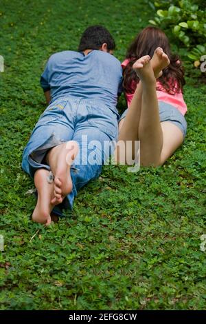 Vue arrière d'un jeune couple lying in a park Banque D'Images