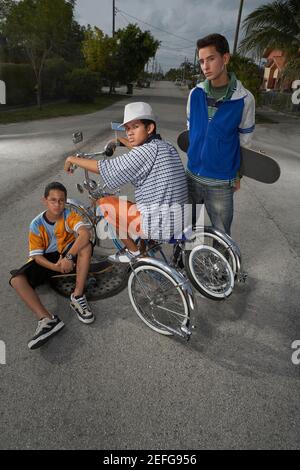 Portrait of a Teenage boy on a low rider vélo avec ses deux amis à côté de lui Banque D'Images