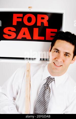 Portrait d'un homme d'affaires tenant pour la vente panneau d'affichage Banque D'Images