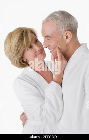Profil latéral d'un homme âgé embrassant une femme mature et souriant Banque D'Images
