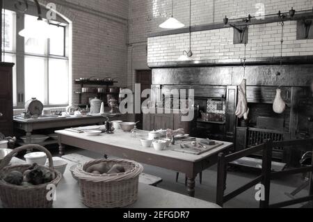 CRAGSIDE cuisine table viande suspendre carreaux fruits assiettes cheminée lumières panier paniers casseroles poêle tables chauffage légumes cuisson Banque D'Images