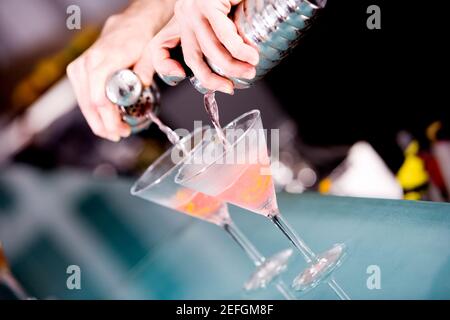 Gros plan d'une main de personnes préparant un cocktail Banque D'Images
