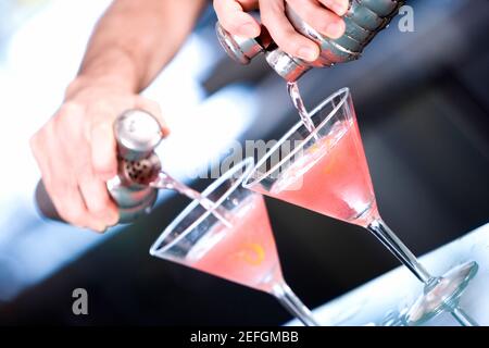 Gros plan d'une main de personnes préparant un cocktail Banque D'Images