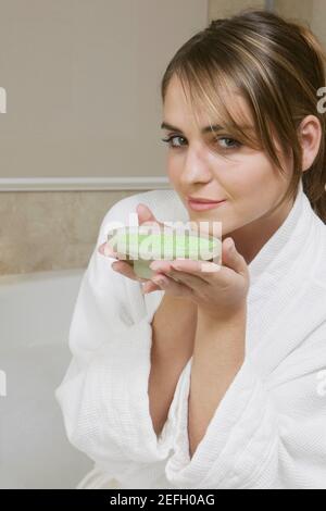 Portrait d'une jeune femme qui sent un plat de bain cristaux Banque D'Images