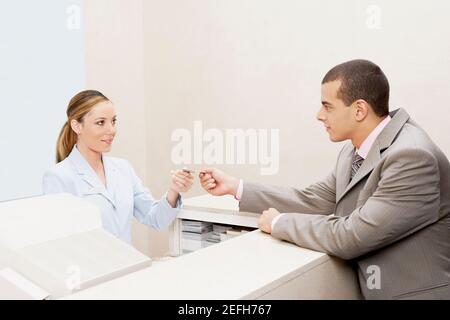 Client donnant une carte de crédit à une réceptionniste Banque D'Images