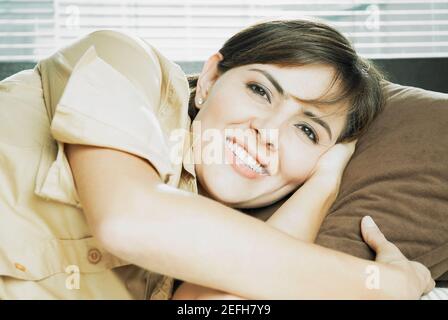 Portrait d'une femme adulte de taille moyenne couché sur le côté et souriant Banque D'Images