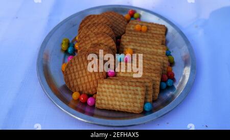 Biscuits de blé dans la plaque d'acier avec fond de noir avec des bonbons colorés. Banque D'Images