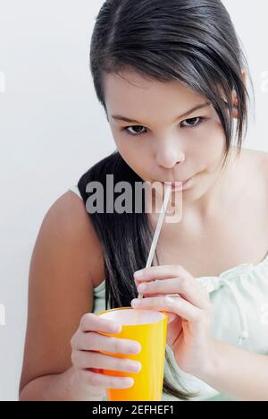 Portrait d'une adolescente qui boit de l'eau avec une boisson paille Banque D'Images