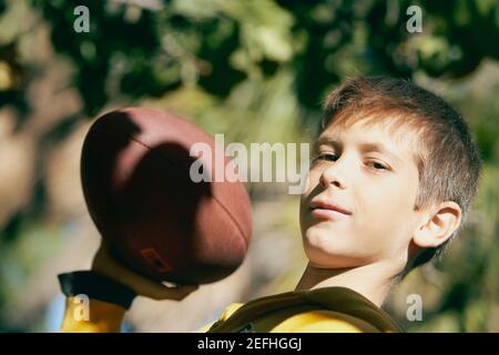 Portrait d'un garçon tenant un ballon de rugby Banque D'Images