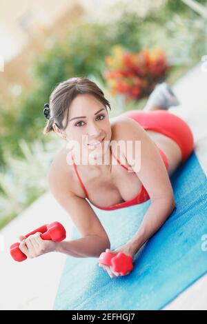 Portrait of a young woman exercising with dumbbells Banque D'Images