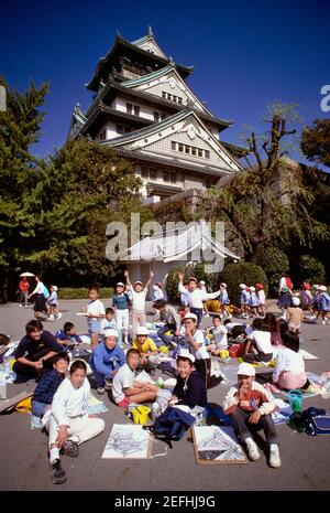 Les écoliers se trouvent devant un château, le château d'Osaka, Osaka, Japon Banque D'Images