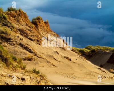 Dunes de sable sur la plage de Morfa Dyffryn entre Barmouth et Harlech à Gwynedd, sur la côte nord-ouest du pays de Galles, avec un ciel orageux au-dessus. Banque D'Images