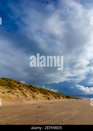 La plage de sable de Morfa Dyffryn entre Barmouth et Harlech à Gwynedd, sur la côte nord-ouest du pays de Galles, avec un ciel orageux au-dessus. Banque D'Images