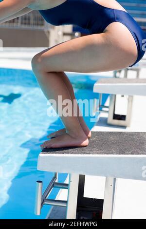 Profil latéral d'une jeune femme prenant le départ d'un plate-forme de plongée Banque D'Images