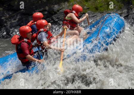 Profil de quatre personnes rafting dans une rivière Banque D'Images