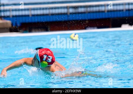 Homme de taille moyenne jouant au water-polo dans une piscine Banque D'Images