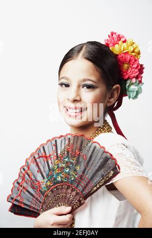 Portrait d'une fille tenant un ventilateur pliant et souriant Banque D'Images