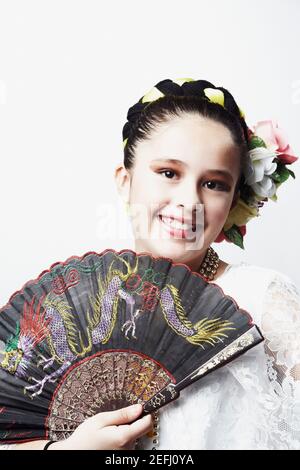 Portrait d'une fille tenant un ventilateur pliant et souriant Banque D'Images