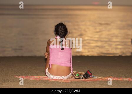 Vue arrière d'une femme assise sur la plage, baie de Taganga, Departamento de Magdalena, Colombie Banque D'Images