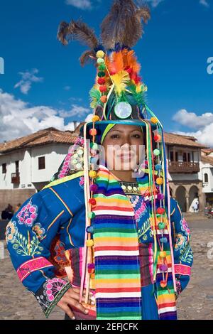 Portrait d'une jeune femme portant un vêtement traditionnel et debout avec des armes akimbo, Pérou Banque D'Images