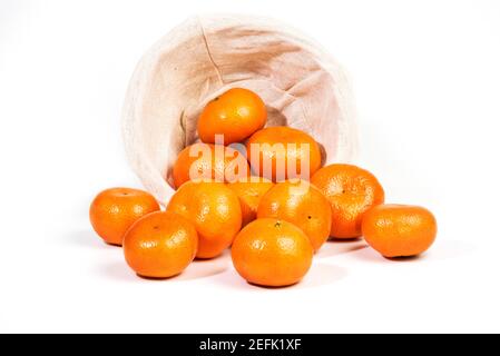 Page mandarines ou mandarines qui se répandent dans un panier, isolées sur un bacille blanc Banque D'Images