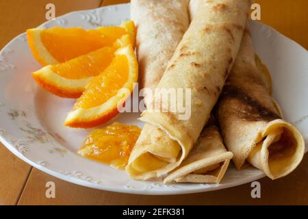 Crêpes à la confiture d'orange et aux oranges - fond en bois Banque D'Images