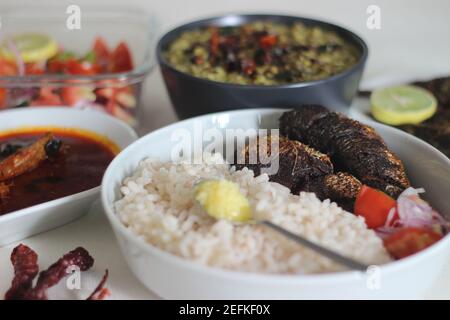 Plats au Kerala avec riz rouge, curry de sardines, friture de sardine et curry de gramme vert à base de noix de coco. Tous préparés dans le style traditionnel du kerala Banque D'Images
